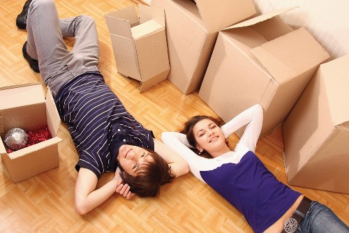 Removal team carrying furniture down stairs during a Northend flat move